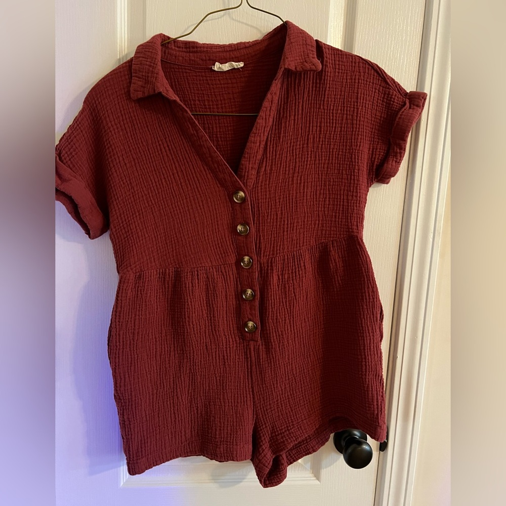 New In romper in a rust color.